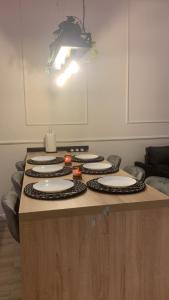 a table with white plates on top of it at 6 OSOBOWY apartament PREMIUM w KAMIENICY - CENTRUM in Gorzów Wielkopolski