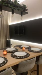 a table with plates on it with candles on it at 6 OSOBOWY apartament PREMIUM w KAMIENICY - CENTRUM in Gorzów Wielkopolski