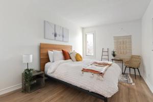 a white bedroom with a bed and a table and chairs at Modern/Rustic 2 Story Condo/3 Min Walk to Village in Blue Mountains