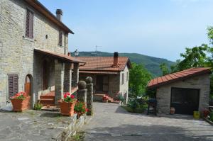un grupo de edificios con flores delante de ellos en Agriturismo Flora, en Chiusi della Verna