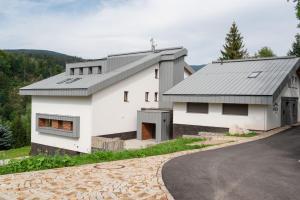 una casa bianca con tetto grigio e vialetto di Vista apartment 18 a Rokytnice nad Jizerou