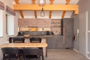 cocina con mesa de madera y sillas negras en Vista apartment 18, en Rokytnice nad Jizerou
