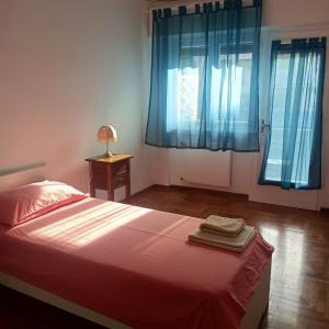 1 dormitorio con 1 cama con cortinas azules y lámpara en B&B Velocipede, en Cervignano del Friuli