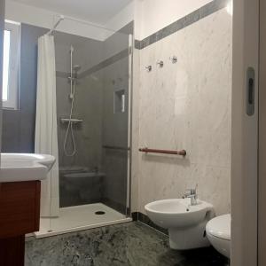 ein Bad mit einer Dusche, einem Waschbecken und einem WC in der Unterkunft B&B Velocipede in Cervignano del Friuli