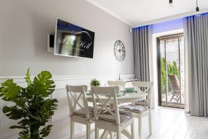 Apartament Sun Hill في فيسلا: غرفة طعام مع طاولة وكراسي وتلفزيون