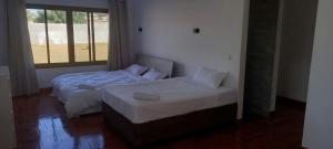 Sequata的住宿－The Hill 4 - Holiday Villa，一间卧室设有两张床、一张沙发和一个窗口
