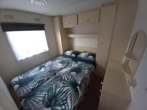 een kleine slaapkamer met een bed en een raam bij Vakantiechalet B6 in Makkum