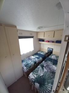 een kleine kamer met 2 bedden en een raam bij Vakantiechalet B6 in Makkum