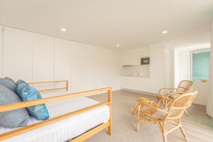 een slaapkamer met een bed en een stoel bij Oceanside West in Ponta Delgada