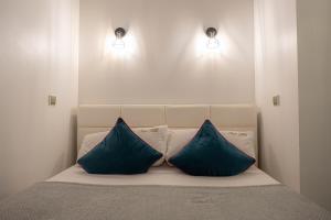 uma cama com duas almofadas azuis em cima em Apartament Sun Hill em Wisla
