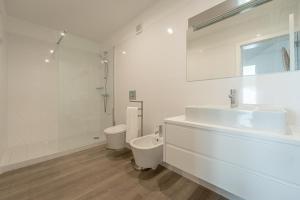 een witte badkamer met een wastafel en een toilet bij Oceanside West in Ponta Delgada +24 foto's