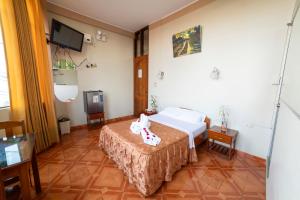 una camera d'albergo con letto e TV di La Torre Valsai a Puerto Maldonado