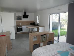 Zimmer mit einem Bett und einer Küche mit einem Tisch in der Unterkunft Studio lumineux avec terrasse in La Roche-sur-Yon