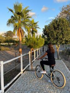 瓦爾杜德弗拉德斯的住宿－Quinta do Pinheiro Hotel Rural - GQL，一名妇女在围栏附近骑着自行车