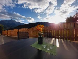 a table with a vase of flowers on a patio at Dolomitenhome Apartments in Patriasdorf