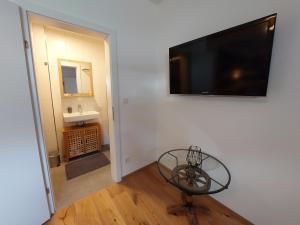 a living room with a flat screen tv on a wall at Dolomitenhome Apartments in Patriasdorf