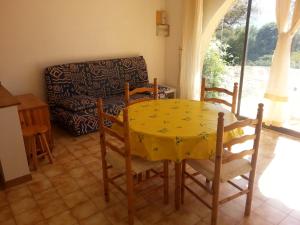 comedor con mesa, sillas y sofá en STUDIO indépendant au calme, en Lumio