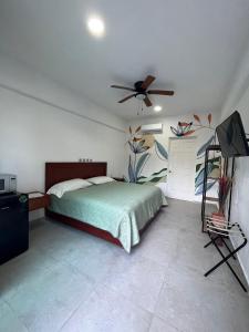 1 dormitorio con 1 cama y ventilador de techo en Residencial Gran Palma en Acapulco