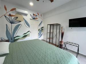 a bedroom with a green bed with a wall mural at Residencial Gran Palma in Acapulco