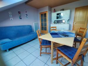 - un salon avec une table et un canapé bleu dans l'établissement gîte La Belle Vue, à La Hoube
