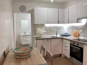 a kitchen with a table and a sink and a clock at A Casinha Gomes in Nisa
