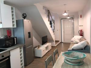 eine Küche und ein Wohnzimmer mit einem Tisch und einem Sofa in der Unterkunft A Casinha Gomes in Nisa