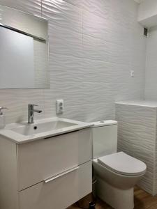 ein weißes Bad mit einem WC und einem Waschbecken in der Unterkunft A Casinha Gomes in Nisa