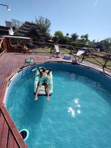 um homem deitado numa jangada numa piscina em Casa quinta em General Rodríguez
