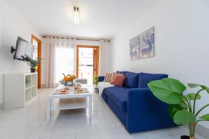 ein Wohnzimmer mit einem blauen Sofa und einem Tisch in der Unterkunft Fidalsa Feel the Sea in El Moncayo