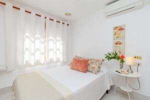 ein weißes Schlafzimmer mit einem Bett und einem Tisch in der Unterkunft Fidalsa Feel the Sea in El Moncayo