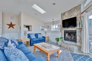 uma sala de estar com um sofá azul e uma lareira em 5233 - Surfin Shamrock em Kill Devil Hills