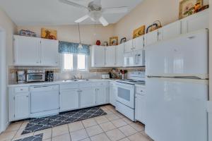 uma cozinha com armários brancos e electrodomésticos brancos em 5233 - Surfin Shamrock em Kill Devil Hills