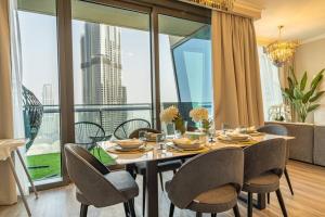 een eetkamer met een tafel en stoelen en een groot raam bij WORLD CLASS 3BR with full BURJ KHALIFA and FOUNTAIN VIEW in Dubai