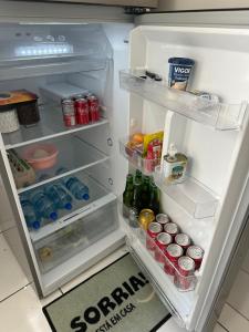 an open refrigerator filled with lots of food and drinks at Apartamento inteiro Varzea Grande MT in Várzea Grande