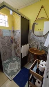 uma casa de banho com um chuveiro e um lavatório. em Chácara do Sapé em São José dos Pinhais