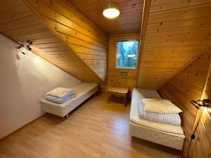 a attic room with two beds and a window at Villa Armas 47 in Äkäslompolo