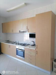 a kitchen with wooden cabinets and a stove top oven at Solaren Apartments Boavista in Sal Rei