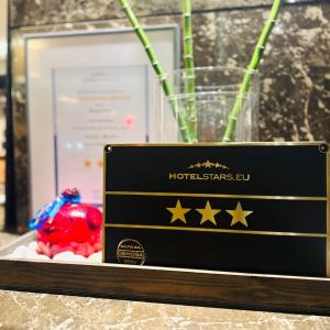 Hotel Post Sindelfingen في شيندلفينجن: علامة سوداء مع نجوم بجوار مزهرية