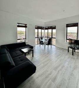 a living room with a black couch and a table at Stunning City Centre Apartments in Waterford