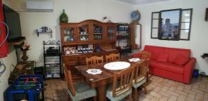 salon ze stołem i czerwoną kanapą w obiekcie Casa Maria w Asyżu