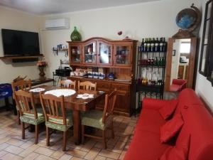een woonkamer met een tafel en een rode bank bij Casa Maria in Assisi
