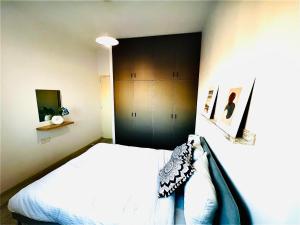 a bedroom with a white bed and a black cabinet at MINA 53 in Larnaka