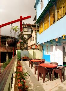 uma fila de mesas e cadeiras ao lado de um edifício em Hidden Monkey Hostels em Darjeeling