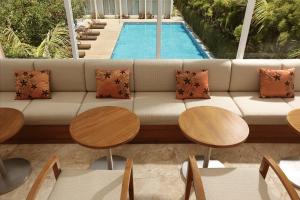 a living room with a couch and tables and a pool at Diamond Hotel Kuta Bali in Kuta