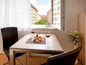 a table with two glasses of wine and a bowl of fruit at Appartement CLASSIC in Graz