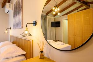 a mirror in a bedroom with two beds and a table at Philoxenia Luxury Apartment in Kritsa