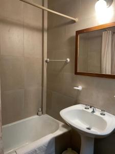 a bathroom with a sink and a tub and a mirror at CASA NONI in Salta