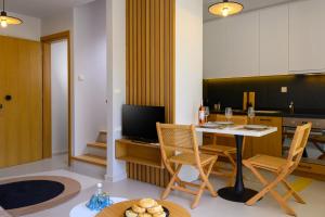 a living room with a table and chairs and a kitchen at Philoxenia Luxury Apartment in Kritsa