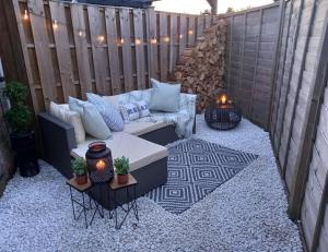 a patio with a couch and a table at Yewtree Cottage in Strensall