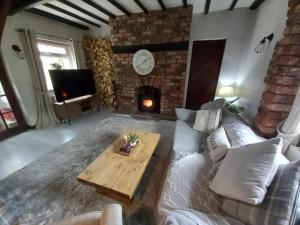 a living room with a couch and a fireplace at Yewtree Cottage in Strensall